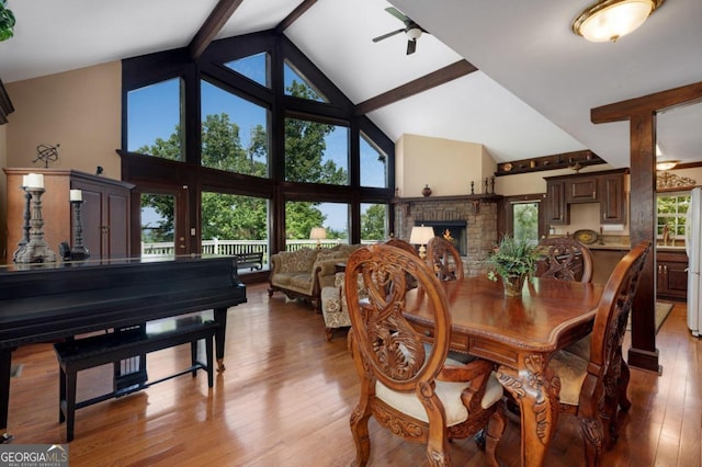 dining room with light wood-style flooring, ceiling fan, high vaulted ceiling, and beamed ceiling