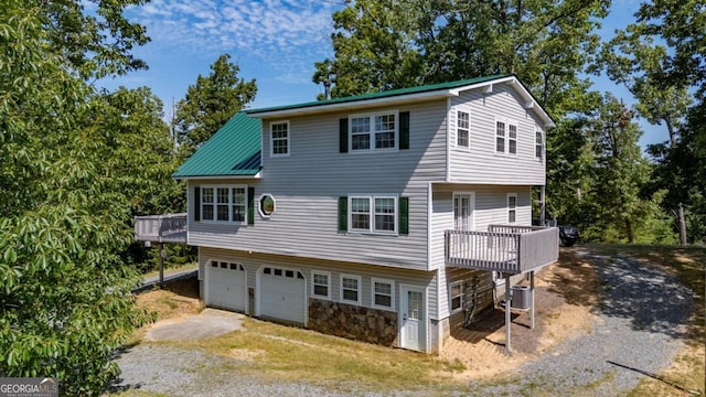 exterior space with a deck, driveway, and an attached garage