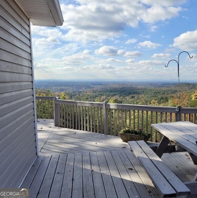 wooden deck with a wooded view