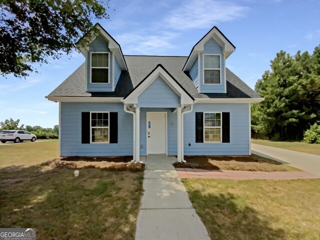 new england style home featuring a front lawn