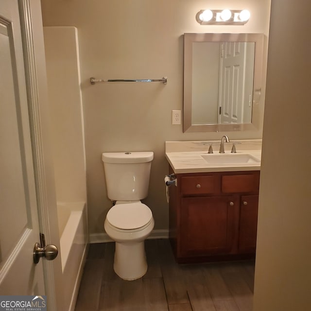 full bathroom featuring shower / washtub combination, hardwood / wood-style floors, toilet, and vanity