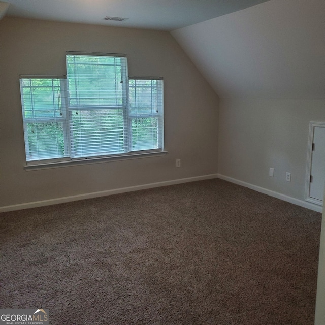 bonus room with vaulted ceiling and carpet flooring