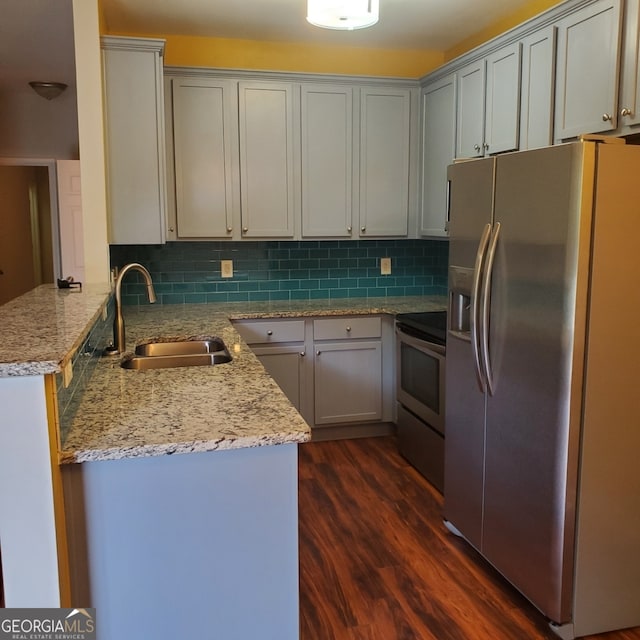 kitchen with range with electric stovetop, light stone countertops, stainless steel fridge, dark wood-type flooring, and sink