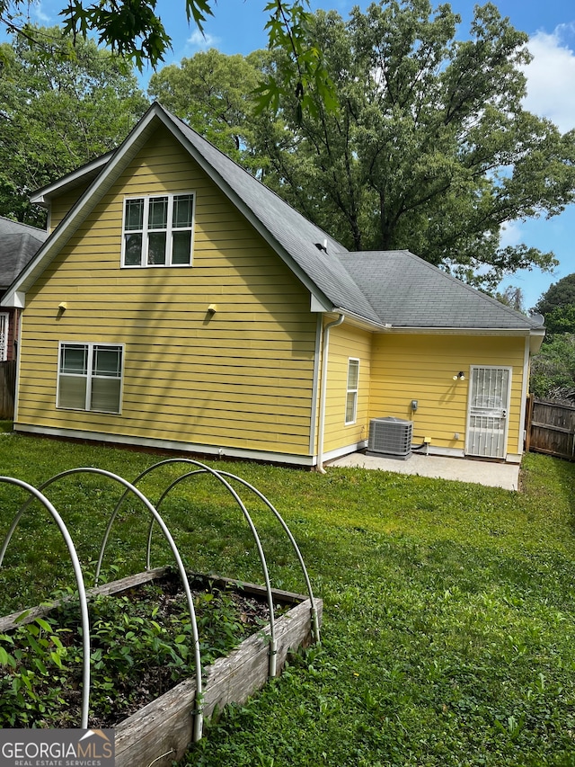 back of property with a lawn and central air condition unit