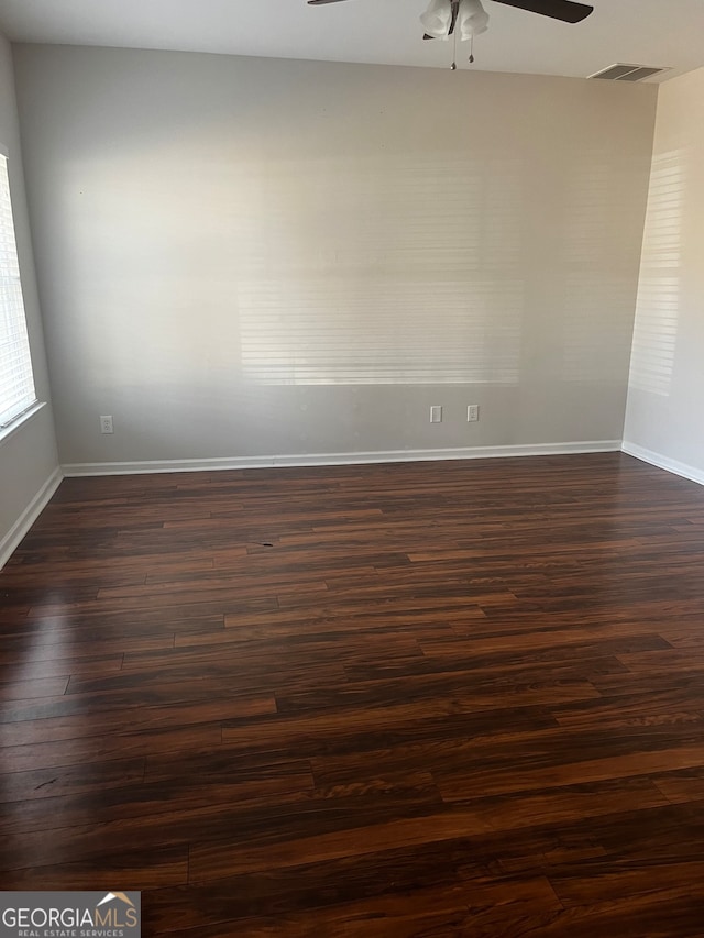 unfurnished room featuring ceiling fan and dark wood-type flooring