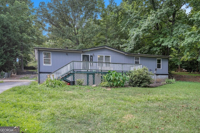 view of front of property featuring a wooden deck and a front lawn