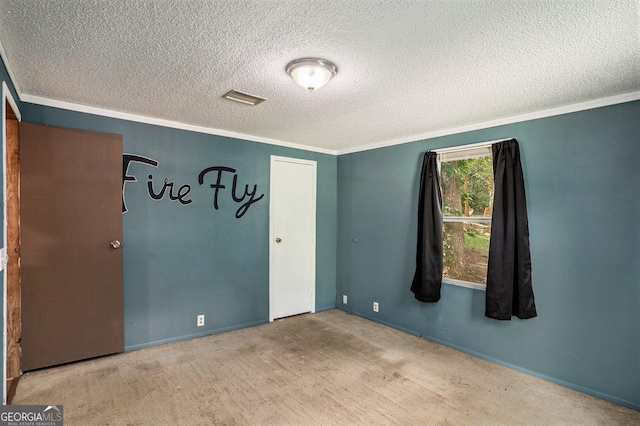 carpeted empty room with crown molding and a textured ceiling