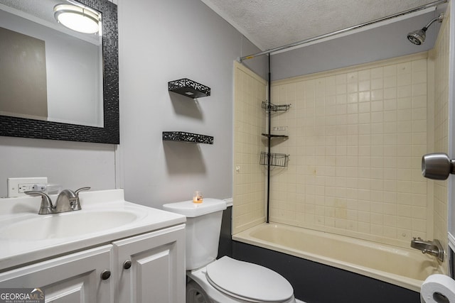 full bathroom with vanity, tiled shower / bath, toilet, and a textured ceiling