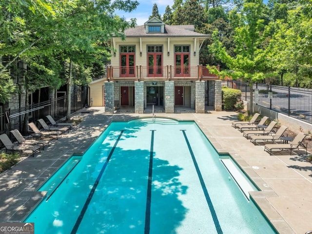 view of swimming pool featuring a patio area, an outbuilding, and french doors