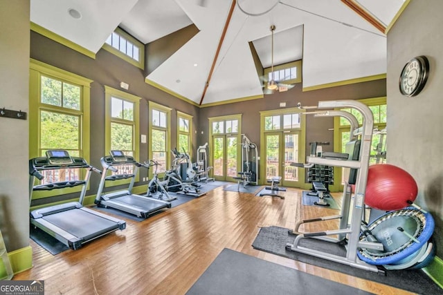 gym featuring high vaulted ceiling, french doors, hardwood / wood-style flooring, and ceiling fan