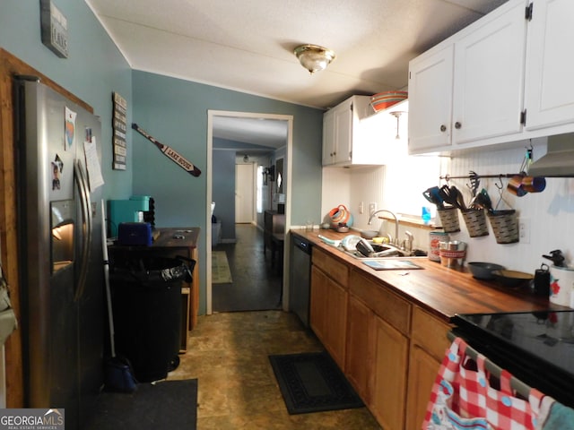 kitchen featuring stainless steel appliances, wall chimney exhaust hood, white cabinets, sink, and lofted ceiling