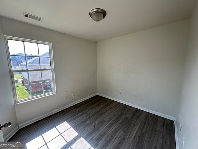 unfurnished room with dark hardwood / wood-style floors