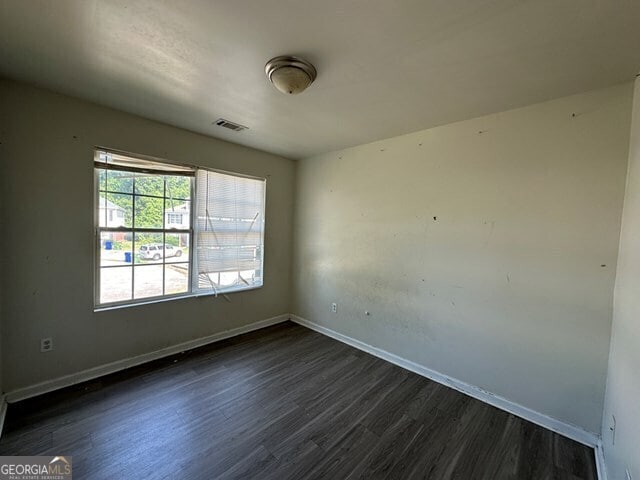 unfurnished room featuring dark hardwood / wood-style floors