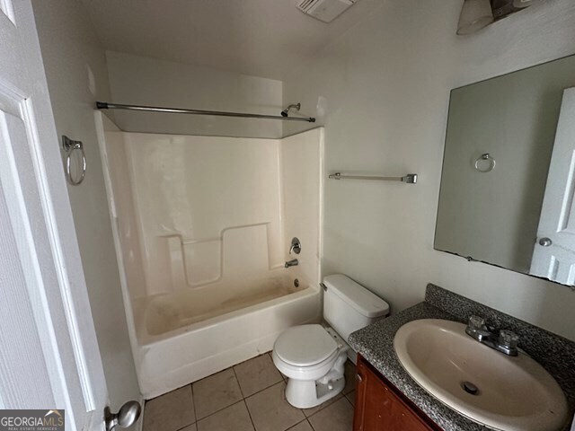 full bathroom featuring tile patterned flooring, vanity, toilet, and  shower combination