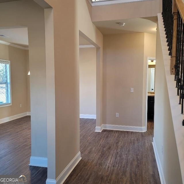 corridor featuring visible vents, baseboards, ornamental molding, dark wood-style flooring, and stairs