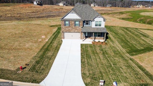 view of front of property featuring an attached garage, a front lawn, and concrete driveway