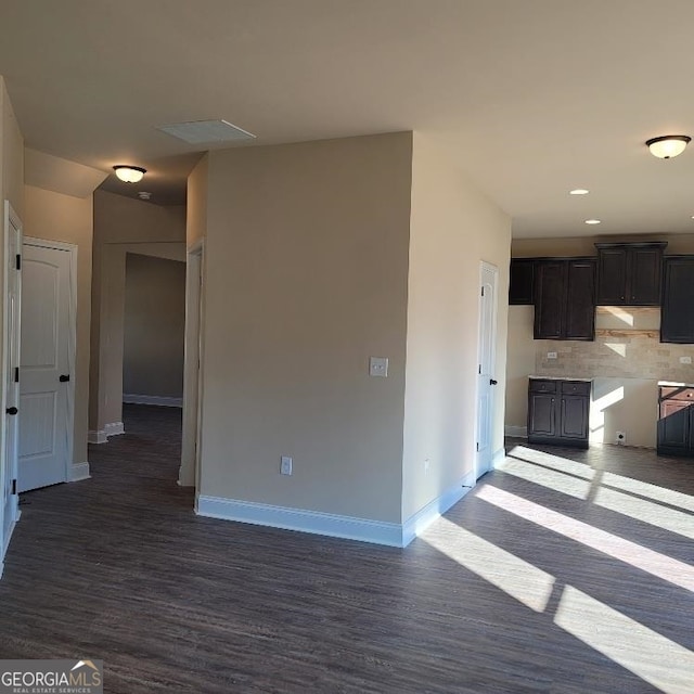 interior space featuring dark wood-type flooring, recessed lighting, backsplash, and baseboards