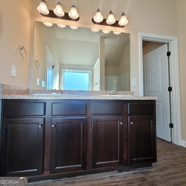 bathroom with hardwood / wood-style flooring, vanity, and vaulted ceiling