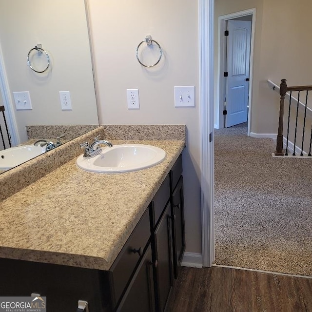 bathroom featuring vanity, baseboards, and wood finished floors