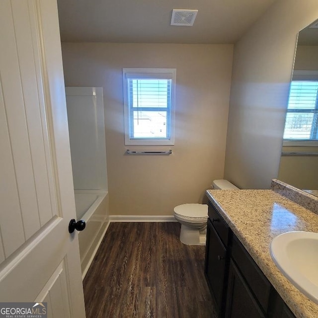 bathroom featuring toilet, wood-type flooring, and vanity