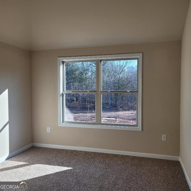 spare room featuring carpet floors and baseboards