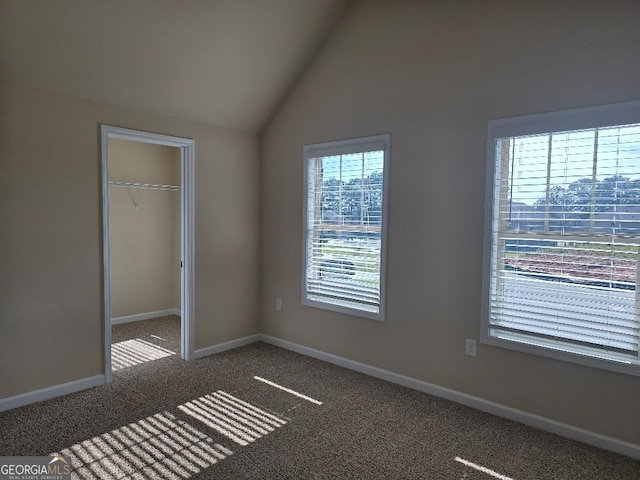 unfurnished bedroom with a spacious closet, high vaulted ceiling, a closet, and carpet floors