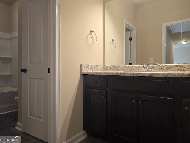 bathroom featuring wood-type flooring, vanity, toilet, and a bathing tub