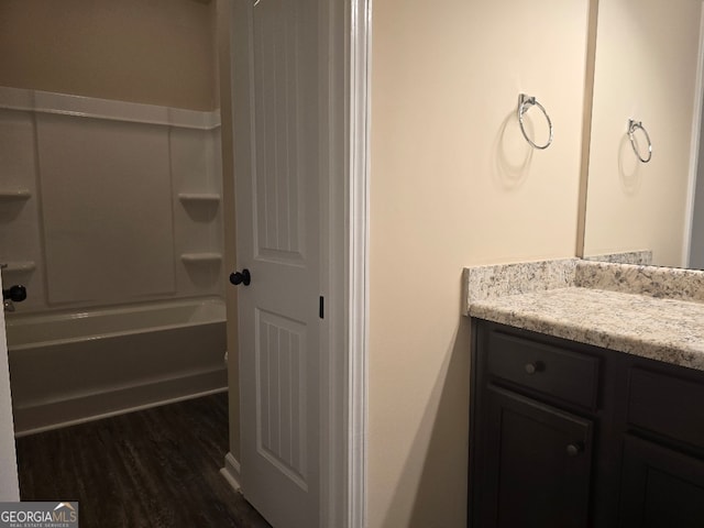 bathroom with vanity, hardwood / wood-style flooring, and tub / shower combination