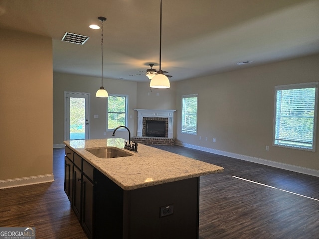 kitchen with ceiling fan, sink, a center island with sink, decorative light fixtures, and dark hardwood / wood-style floors