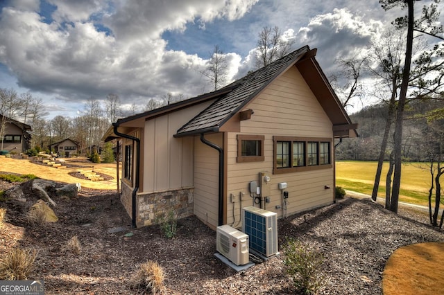 view of side of home featuring central air condition unit and ac unit