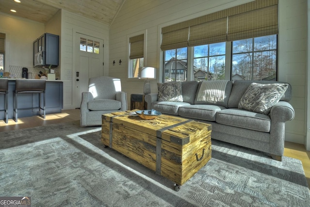 living room with high vaulted ceiling and wooden ceiling