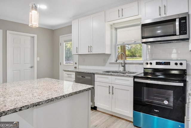 kitchen with decorative backsplash, sink, white cabinetry, and stainless steel appliances