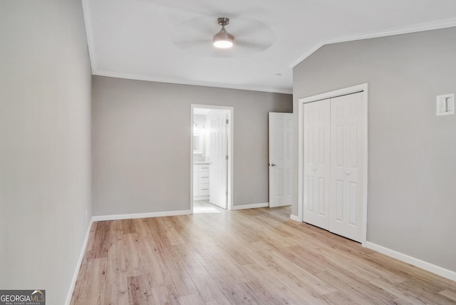 unfurnished bedroom featuring ceiling fan, a closet, crown molding, and light wood-type flooring