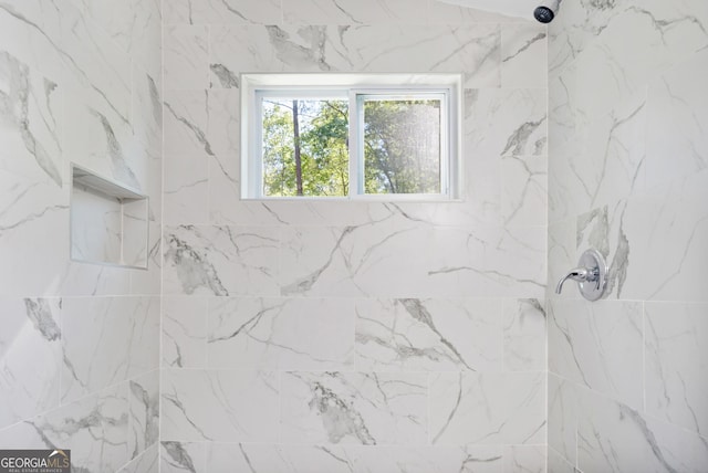 interior details featuring a tile shower