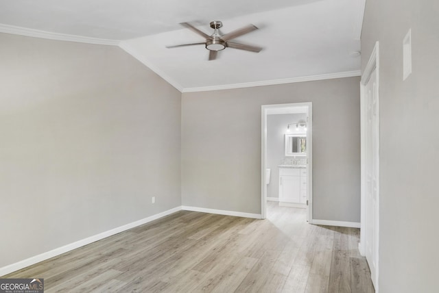 spare room featuring light hardwood / wood-style floors, vaulted ceiling, ceiling fan, and crown molding