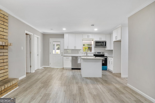 kitchen with crown molding, a center island, white cabinets, and stainless steel appliances