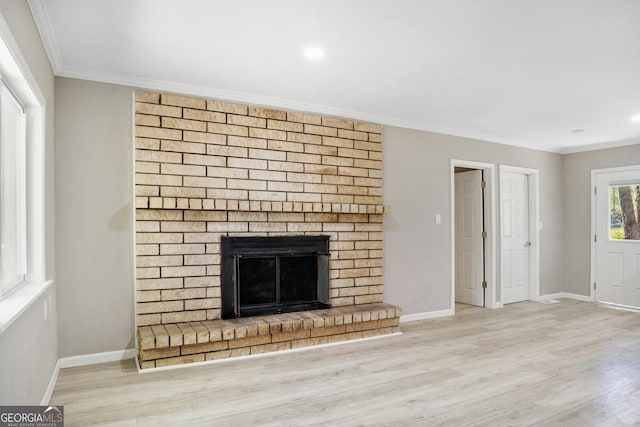 unfurnished living room featuring a fireplace, light hardwood / wood-style flooring, and ornamental molding