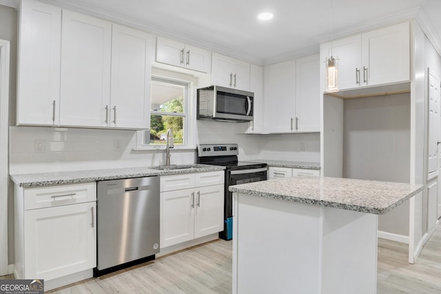 kitchen with white cabinets, sink, light hardwood / wood-style floors, a kitchen island, and stainless steel appliances