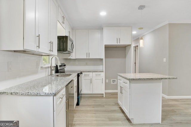 kitchen featuring light stone counters, crown molding, pendant lighting, white cabinets, and a center island