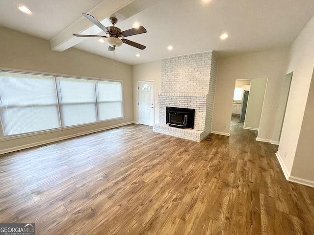 unfurnished living room featuring ceiling fan, lofted ceiling with beams, and wood-type flooring