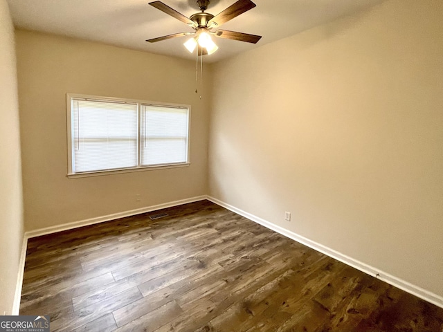 empty room with ceiling fan and dark hardwood / wood-style floors