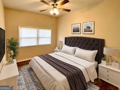 bedroom with ceiling fan and dark wood-type flooring