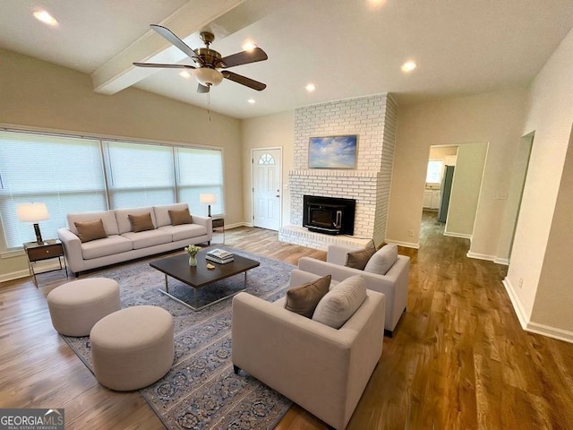 living room featuring beamed ceiling, ceiling fan, and hardwood / wood-style flooring