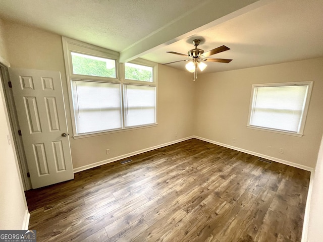 spare room featuring beamed ceiling, ceiling fan, dark hardwood / wood-style floors, and a textured ceiling