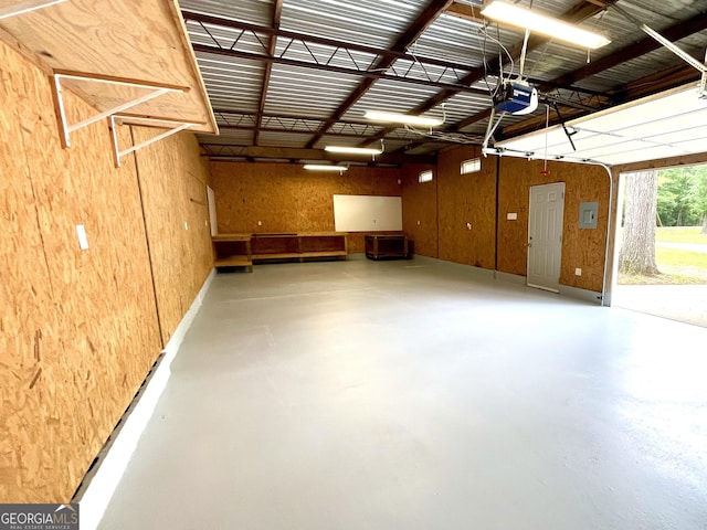 garage with wooden walls and a garage door opener