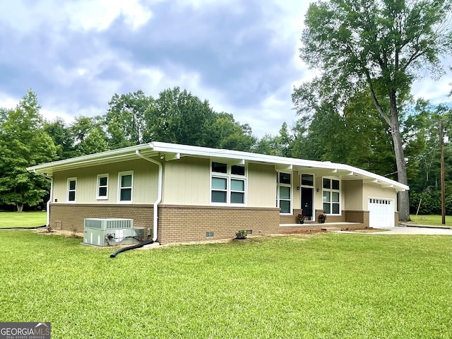 ranch-style house with a front lawn, cooling unit, and a garage