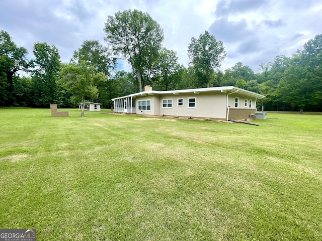 rear view of house featuring a yard