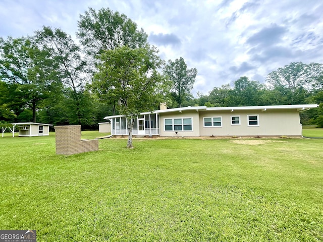 rear view of house featuring a yard