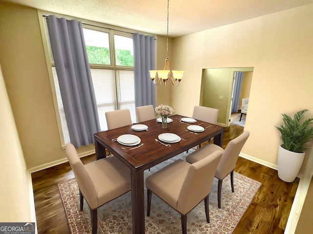 dining room with dark hardwood / wood-style flooring and a chandelier