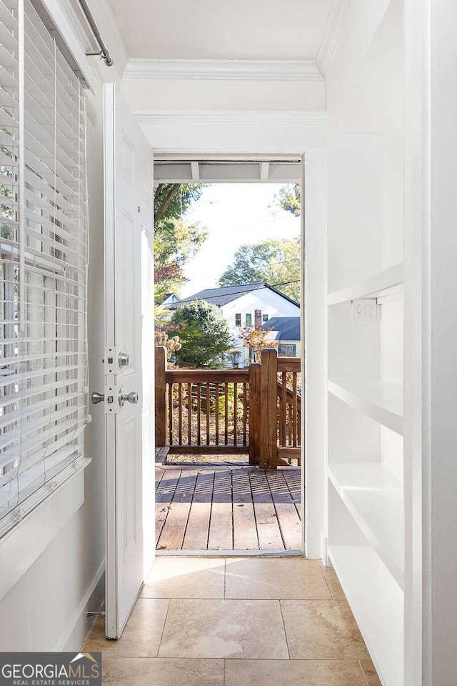 doorway featuring tile patterned flooring and ornamental molding